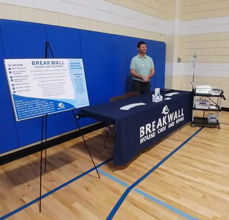 home wound care physical therapy Erie PA. The owner of Breakwall Wound Care and Rehab standing at his YMCA Health Fair booth.