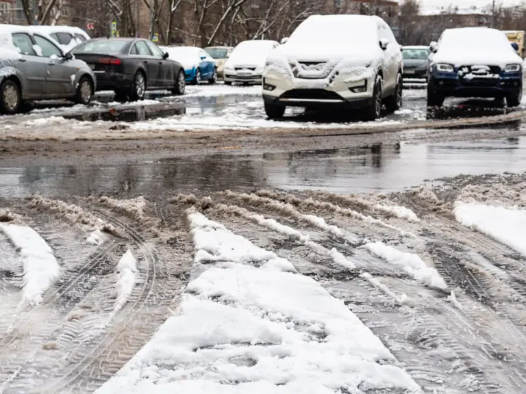 This is a slushy and snowy parking lot with snow covered cars and tire tracks for use in a 2 minute warm up winter fall prevention post