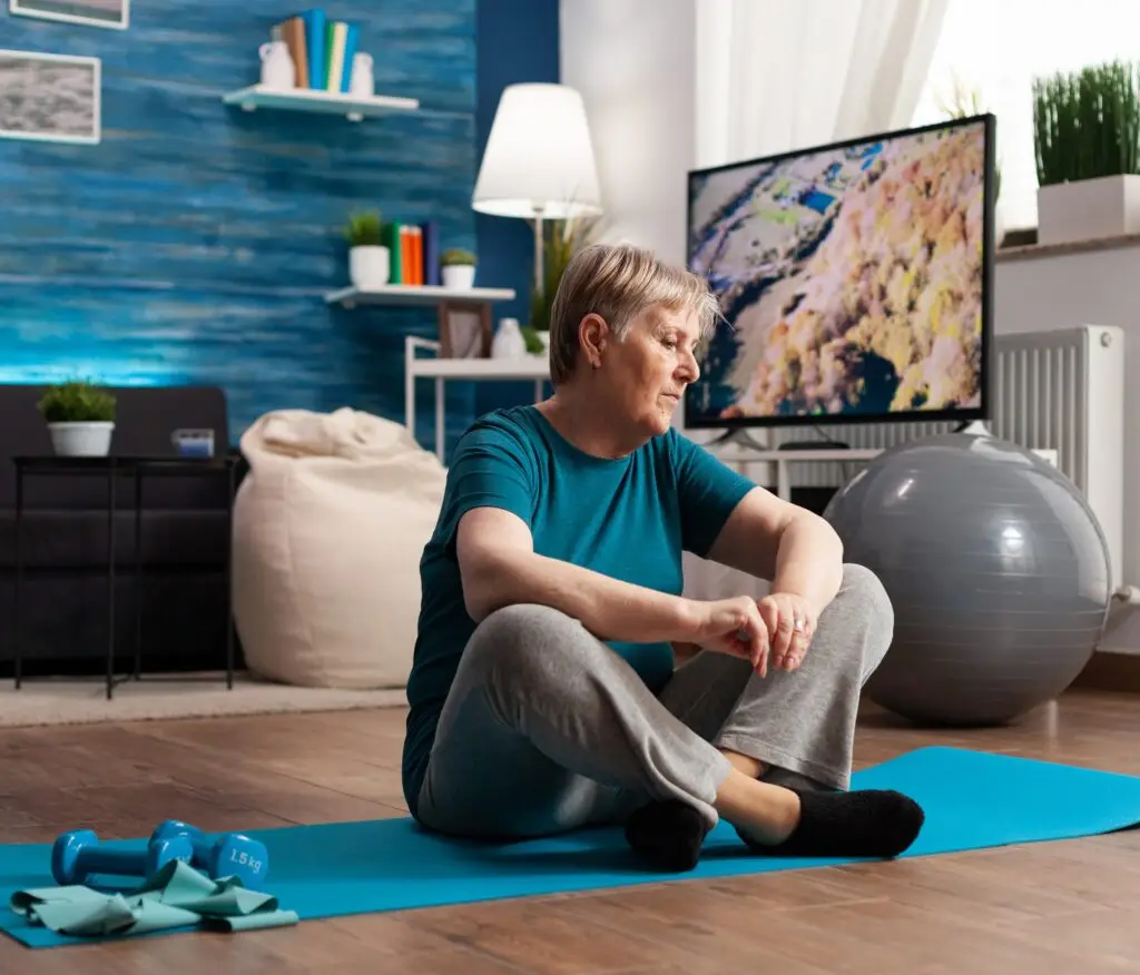 senior woman sitting lotus position yoga mat training body muscles slimming weight in home physical therapy and wound care erie pa